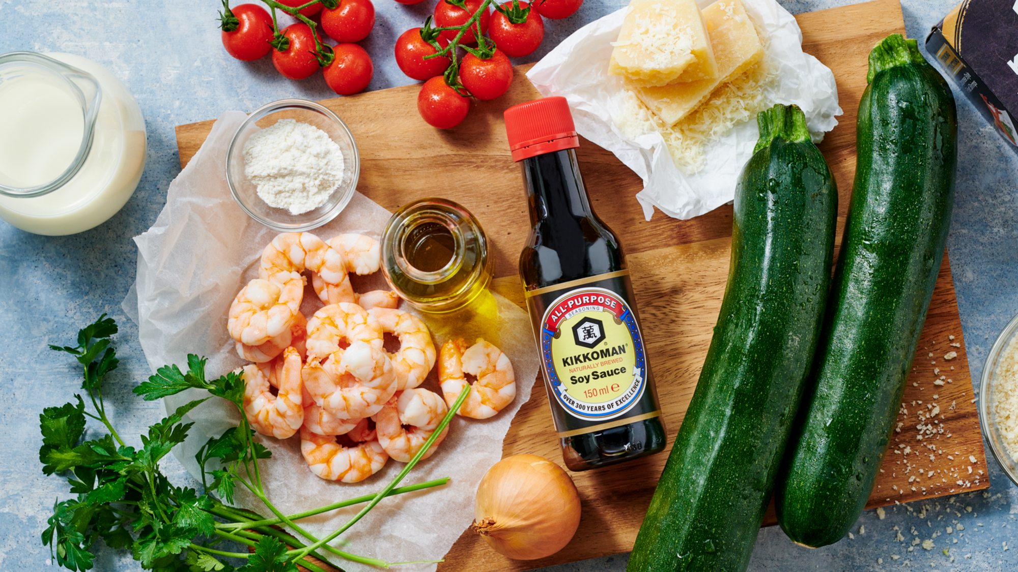 Soijat: Kikkoman soijakastikepullo leikkuulaudan päällä, jossa kasviksia ja katkarapuja