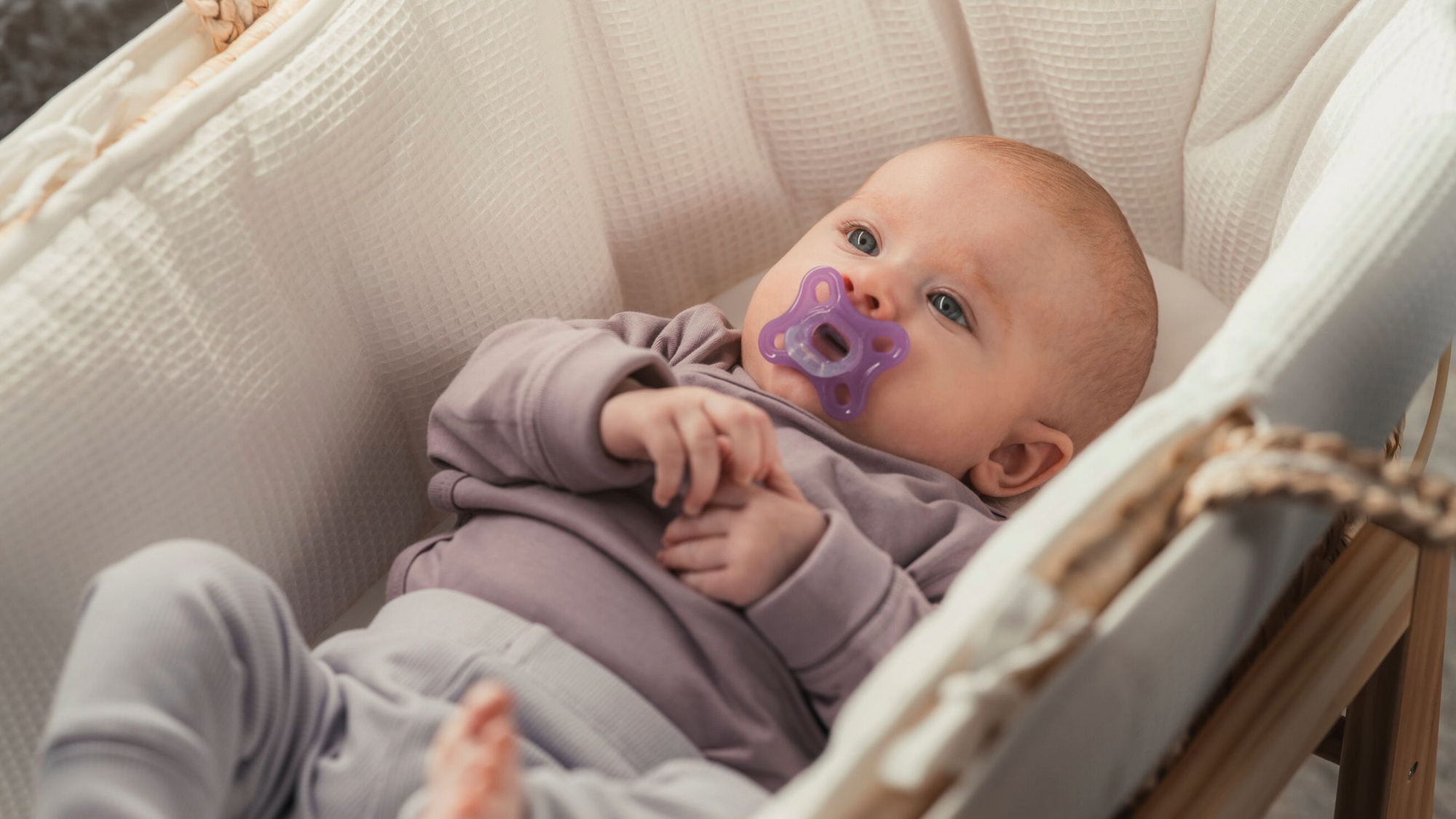 Vauvanhoito: Vauva makaa kehdossa Ainu tutti suussa