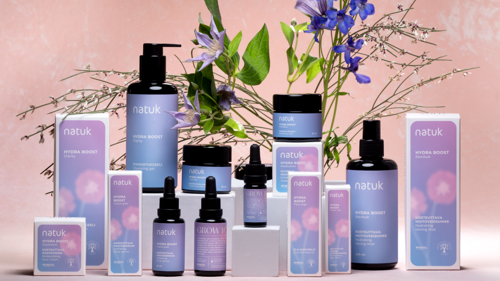 Natuk tuotteita ja lilan värisiä kukkia pöydällä 