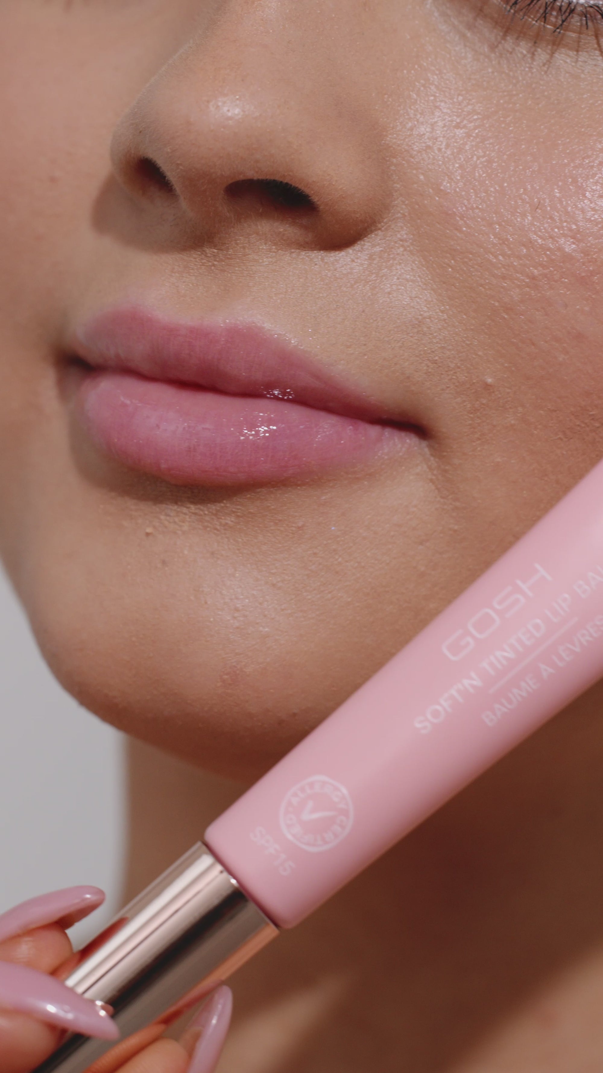 Girl applying pink lip gloss